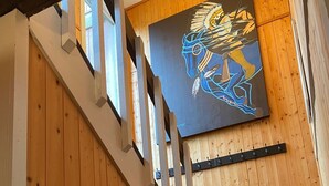 Eine Holztreppe mit einem modernen Kunstwerk darüber.