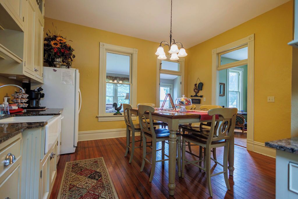 A kitchen with wooden cabinets, a dining table with chairs, and a chandelier.