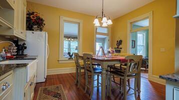 A kitchen with wooden cabinets, a dining table with chairs, and a chandelier.