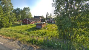 A rural property with multiple buildings, a well-maintained lawn, and surrounding trees. - Björnforsens Turist & Konferens Hotell (Bjorna)
