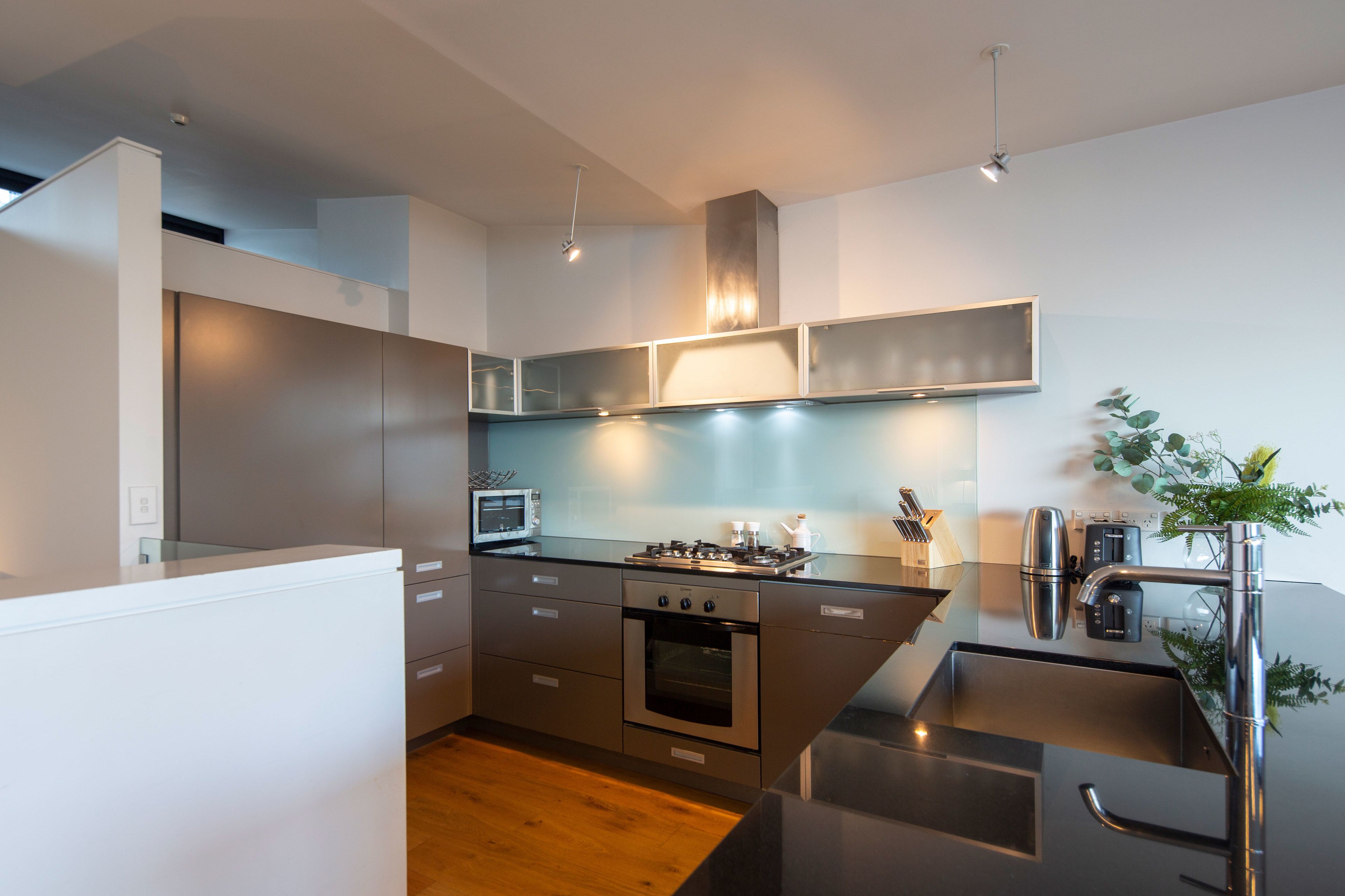 A modern kitchen with stainless steel appliances, a built-in oven, and a microwave.