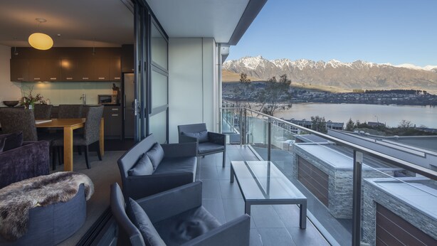 A modern living area with a balcony overlooking a lake and mountains. - Panorama Terrace Apartments, Element Escapes (Queenstown)