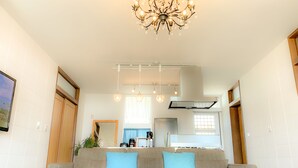 A modern living room with a sofa, a coffee table, and a chandelier. - Resort Villa Kouri island Aqua Blue (Nakijin)