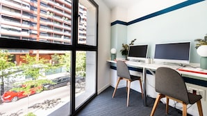 A modern office space with two desks, chairs, and large windows offering a view of a residential area. - Moontels Valencia Alameda 41 (Valencia)