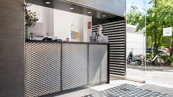 Een receptiegedeelte met een modern design, inclusief een behang met patroon en een receptiebalie.