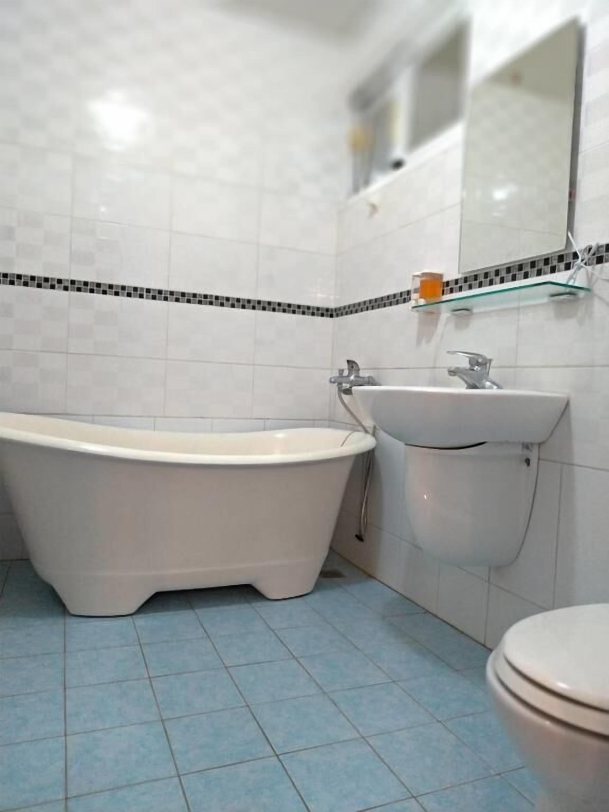 A bathroom with a freestanding bathtub, a sink, and a toilet.