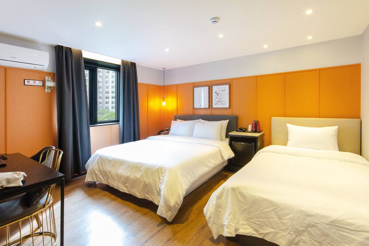 Una habitación de hotel con dos camas, un escritorio y una silla.