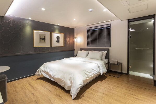 A modern bedroom with a large bed, a small bedside table, and a wall-mounted picture frame. - Browndot Hotel Centum City Bexco (Busan)