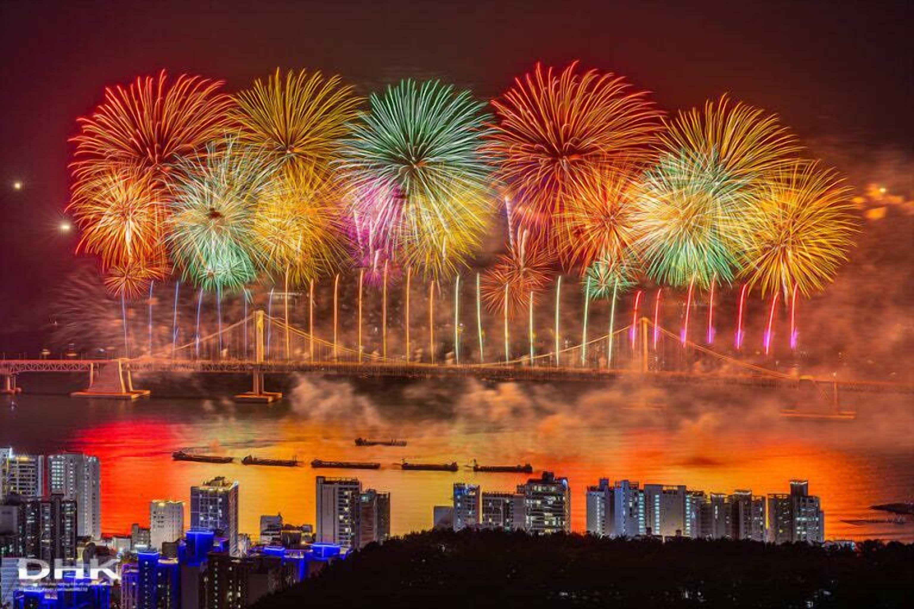 A cityscape with a bridge and fireworks display.