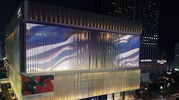 A modern hotel with a large digital display on the facade, a covered outdoor area, and a visible entrance.