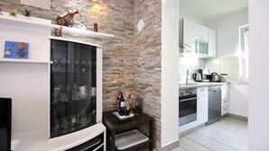 A modern kitchen with white cabinets, a built-in microwave, and a dishwasher.