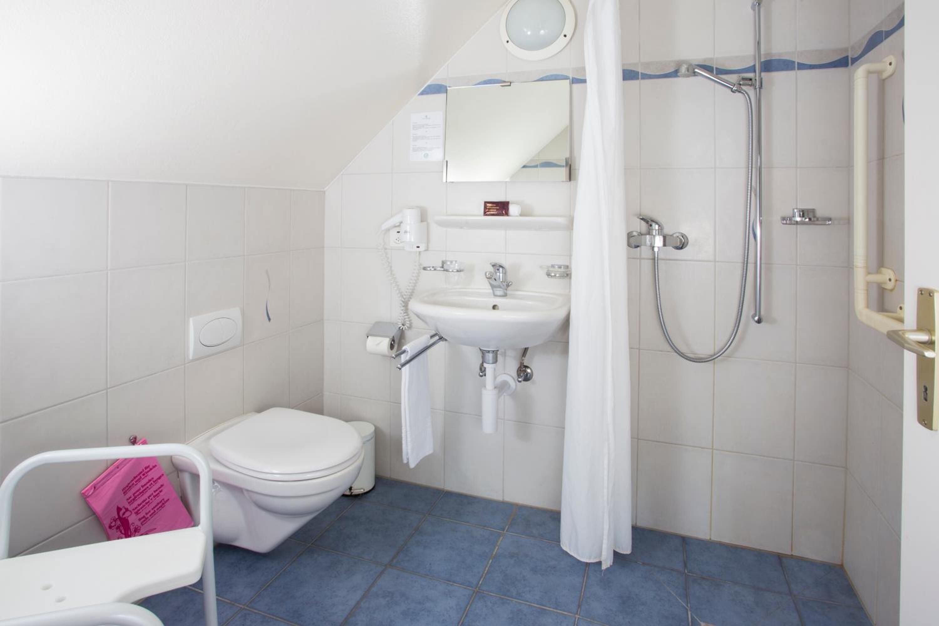 Une salle de bain avec des toilettes, un lavabo et une douche.
