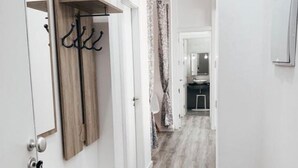 A hallway with a wooden floor, a coat rack, and a mirror on the left wall. - ALICANTE CENTER APART THE PENTHOUSE WITH TERRACE (Alicante (Alacant))