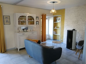 A living room with a sofa, a cabinet with glass doors, a small round table, and a television. - Frehel: country holiday homes - 4 rooms - 1/6 persons (Frehel)