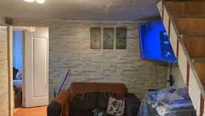 Un soggiorno con divano, televisore e parete con pannelli decorativi.