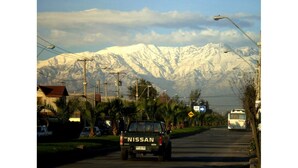 Un pick-up Nissan su una strada con montagne sullo sfondo.