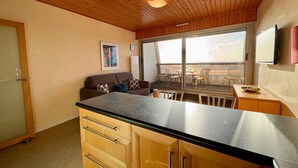 A compact kitchen with wooden cabinets and a black countertop.