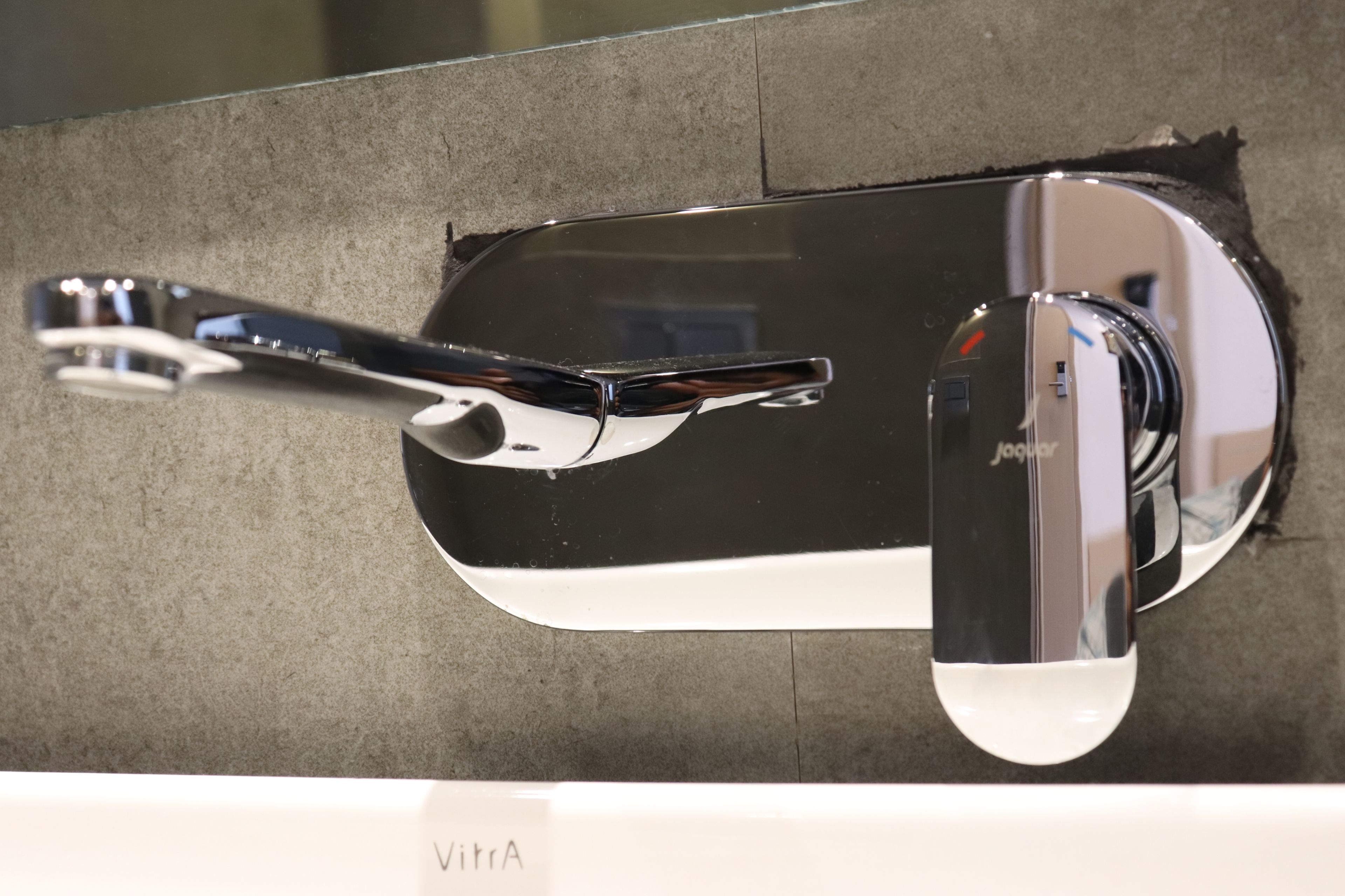 Un baño moderno con grifo cromado y espejo.