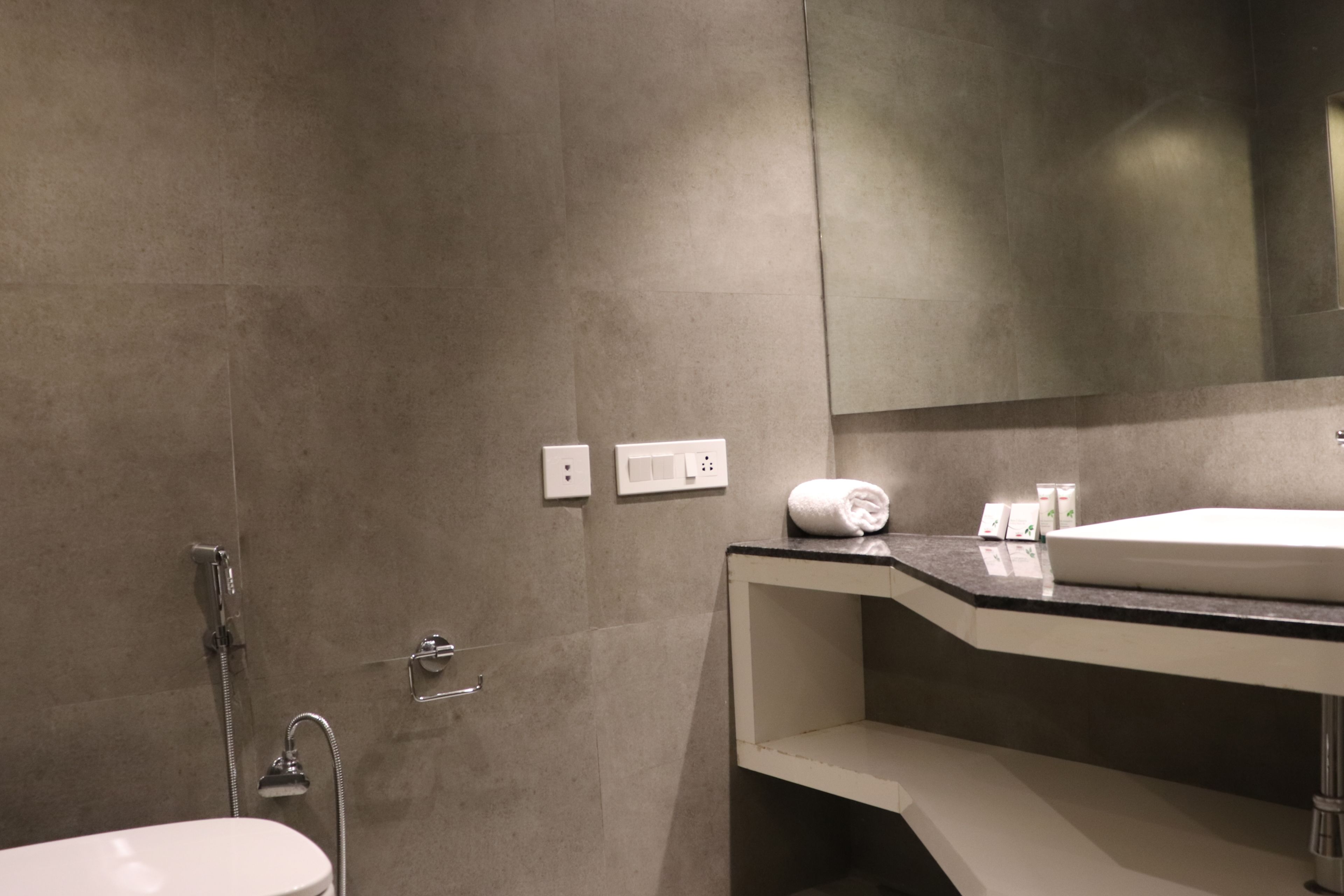 Un baño moderno con un lavabo blanco, un espejo y una ducha.