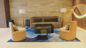 A modern living room with a sofa, two armchairs, a coffee table, and two floor lamps.