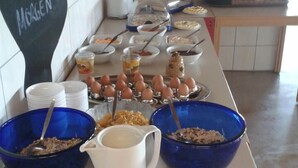 Un bufé de desayuno con diferentes alimentos y recipientes.