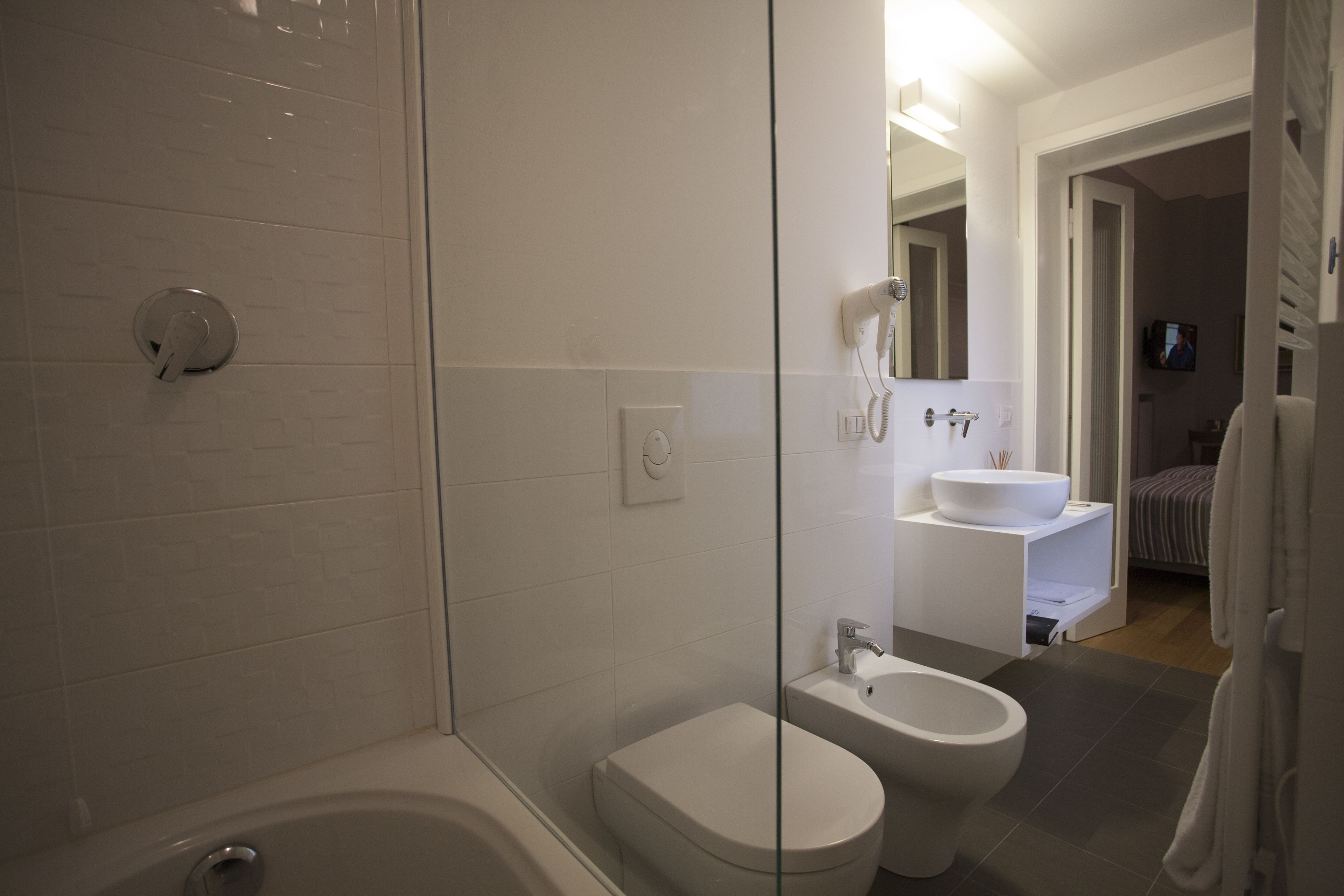 A modern bathroom with a bathtub, toilet, and bidet.