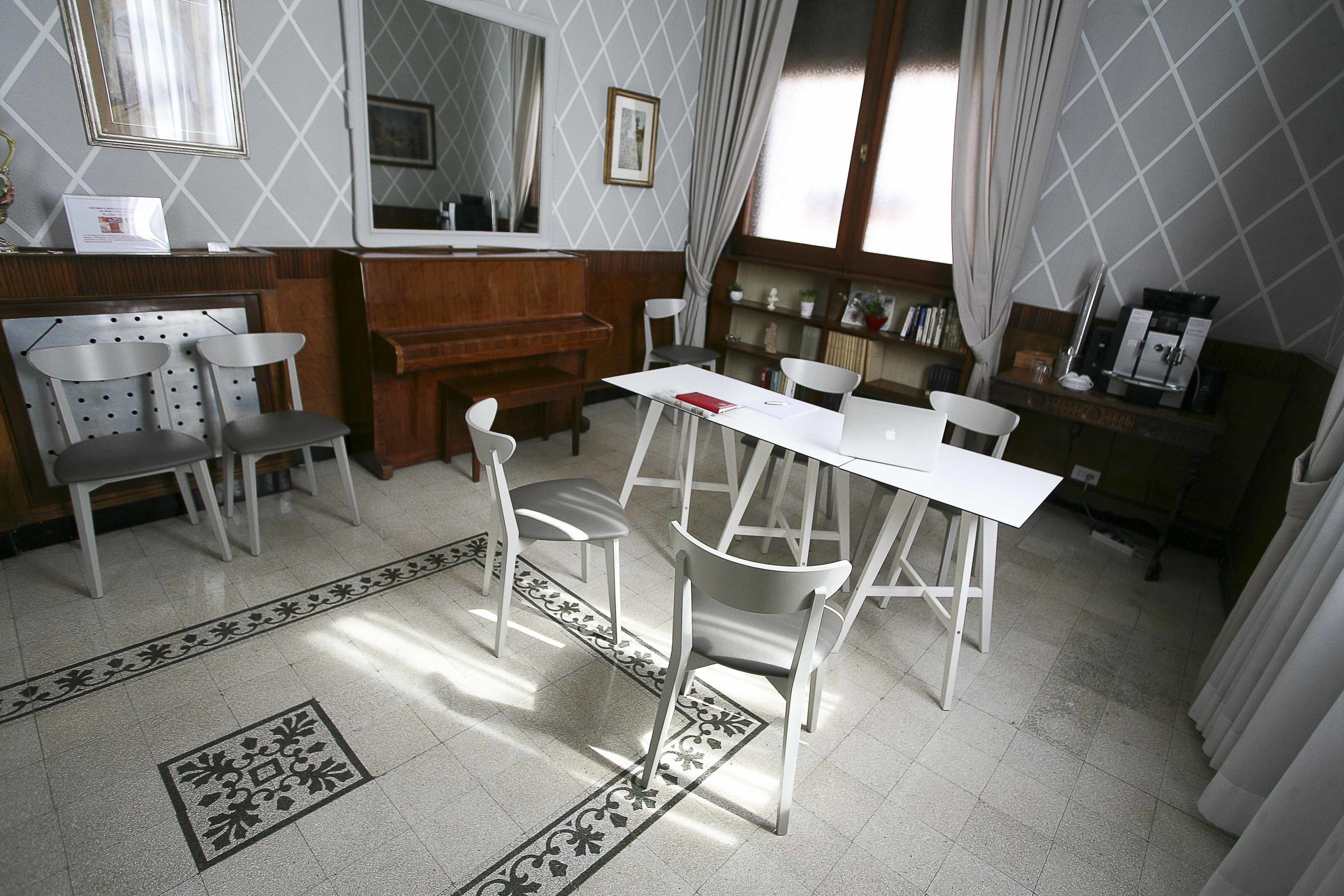 A dining area with a white table and chairs, a wooden counter, and a bookshelf.