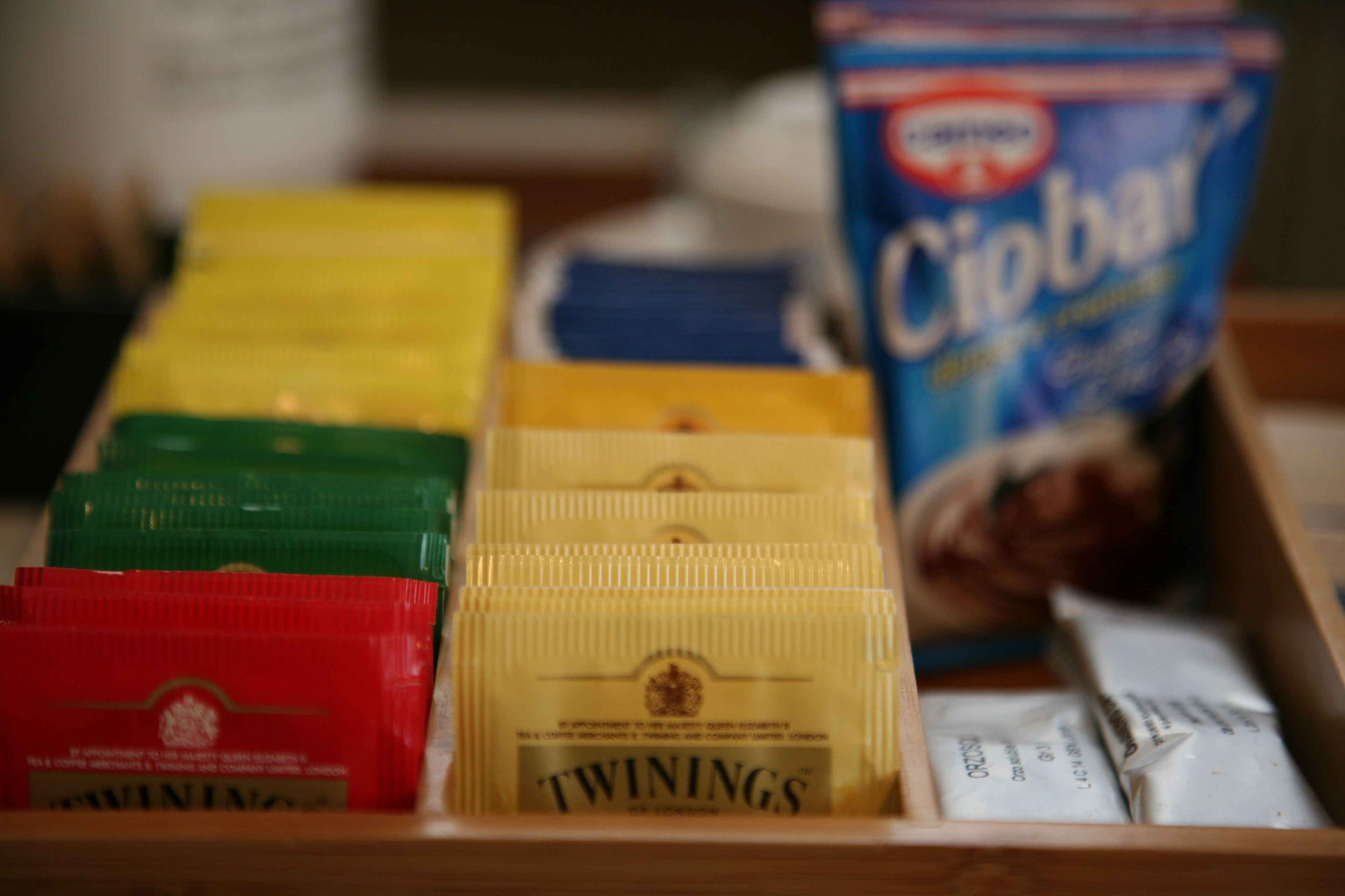 Eine Schublade mit verschiedenen Lebensmitteln, darunter Twinings Teebeutel, Cibbar-Cereal und andere verpackte Waren.