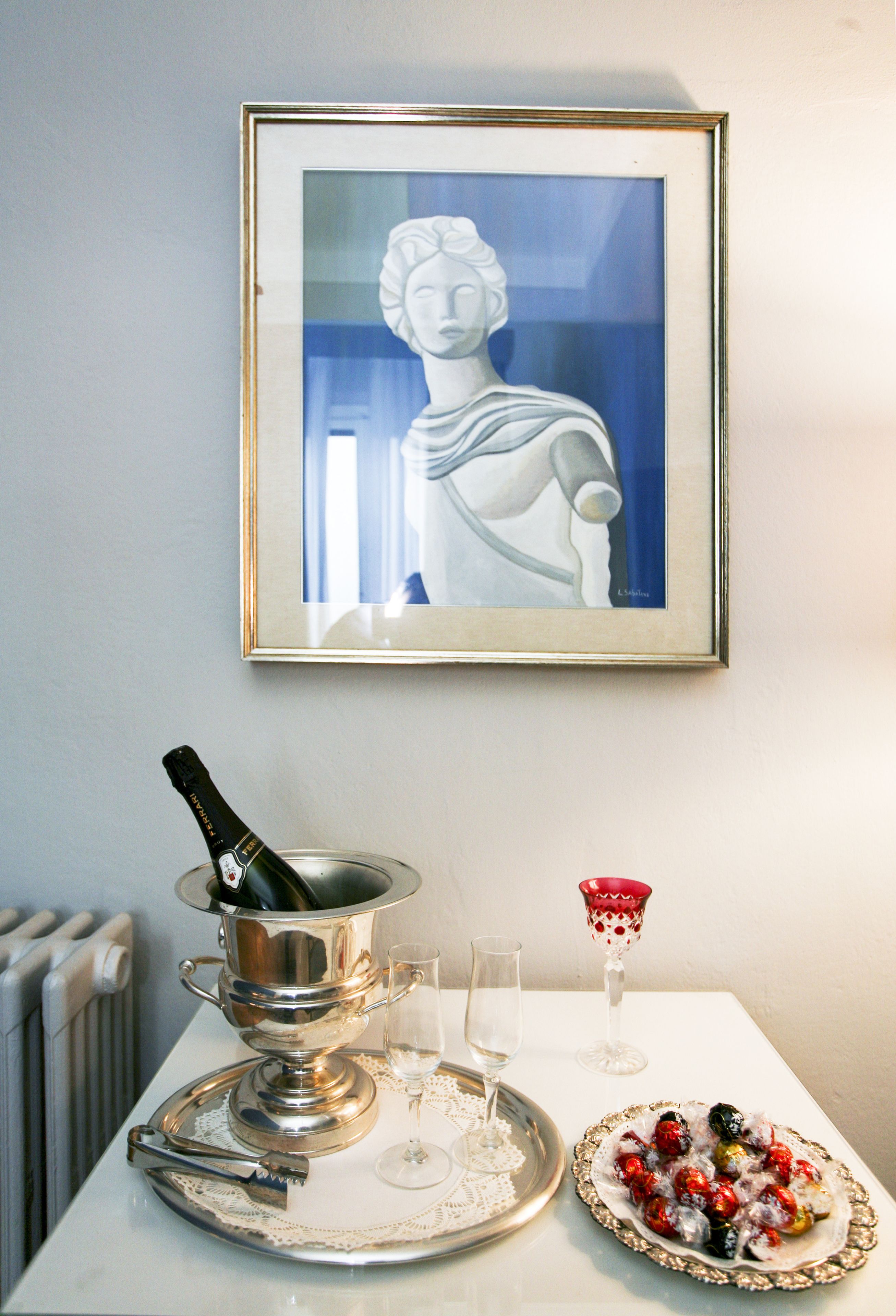 A table with a champagne bottle, glasses, and a plate of fruit.