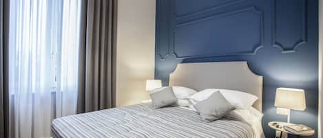 Standaard tweepersoonskamer | Een minibar, een kluis op de kamer, een bureau, verduisterende gordijnen