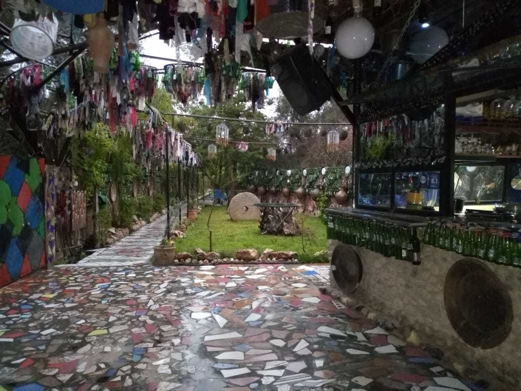 A room with a mosaic floor, hanging decorations, and a bar area with bottles.