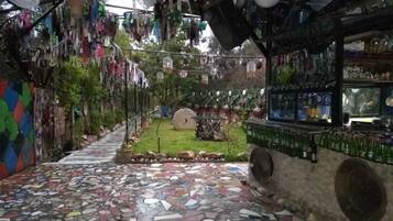 A room with a mosaic floor, hanging decorations, and a bar area with bottles.