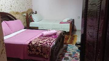 Una camera da letto con due letti, un tappeto colorato e un decoro a parete.