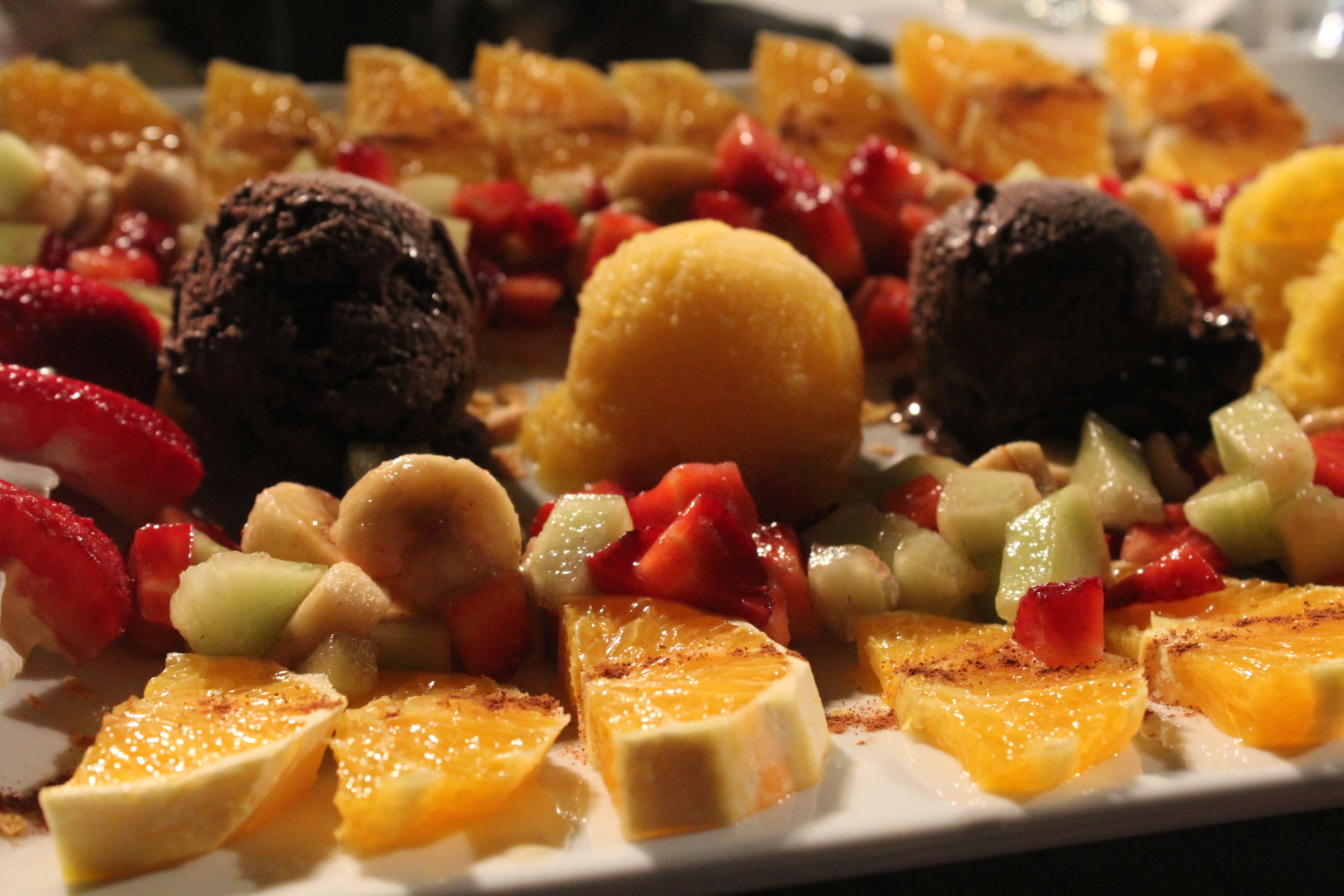 A dessert plate with various fruits and chocolate desserts.