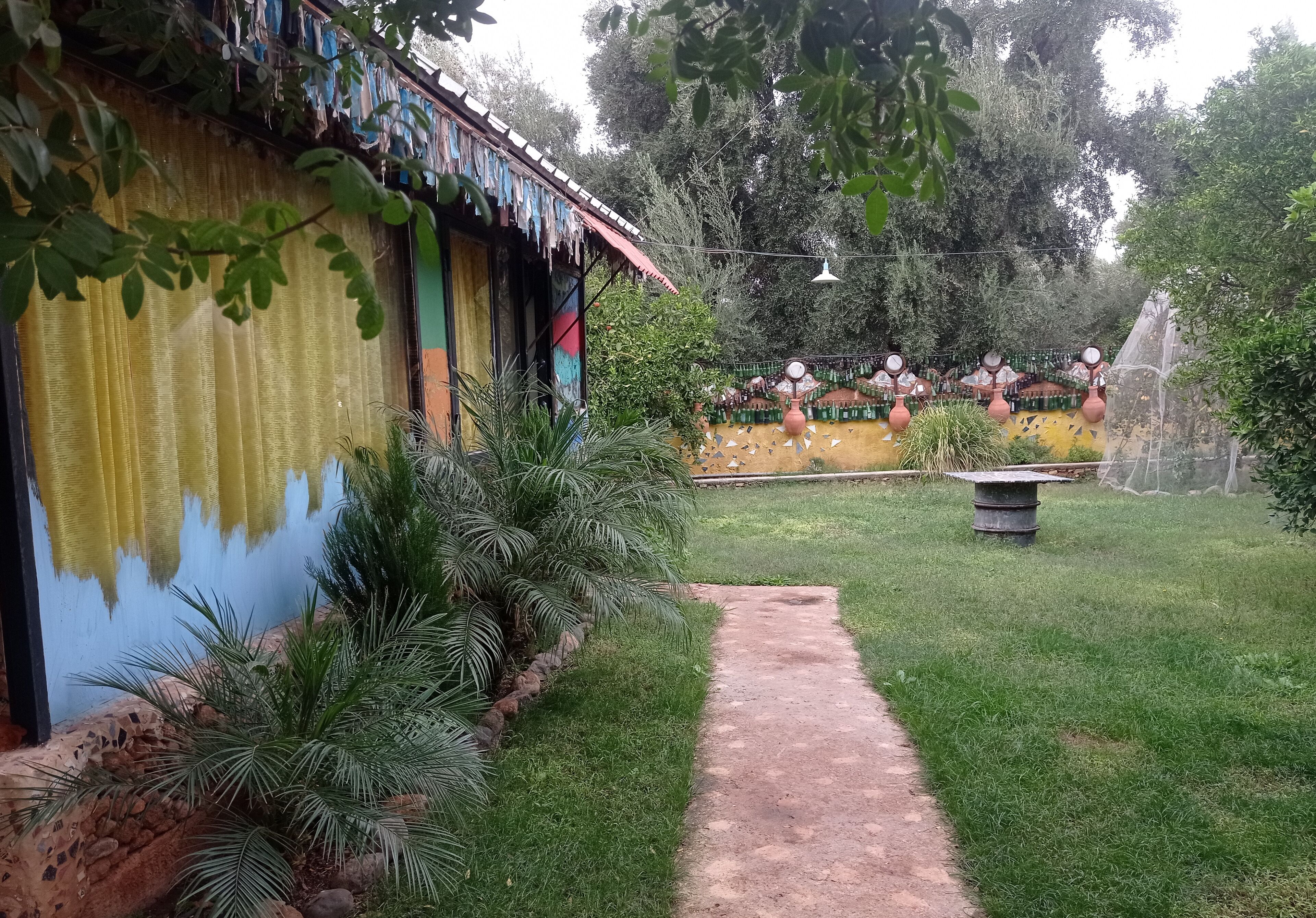 Un jardín con un sendero que conduce a un edificio de fachada colorida.