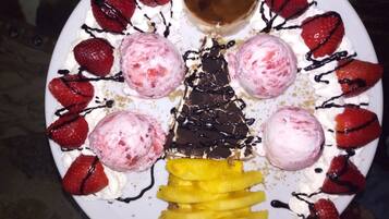 Ein Dessertteller mit Erdbeeren, Eis und einem Stück Schokolade.