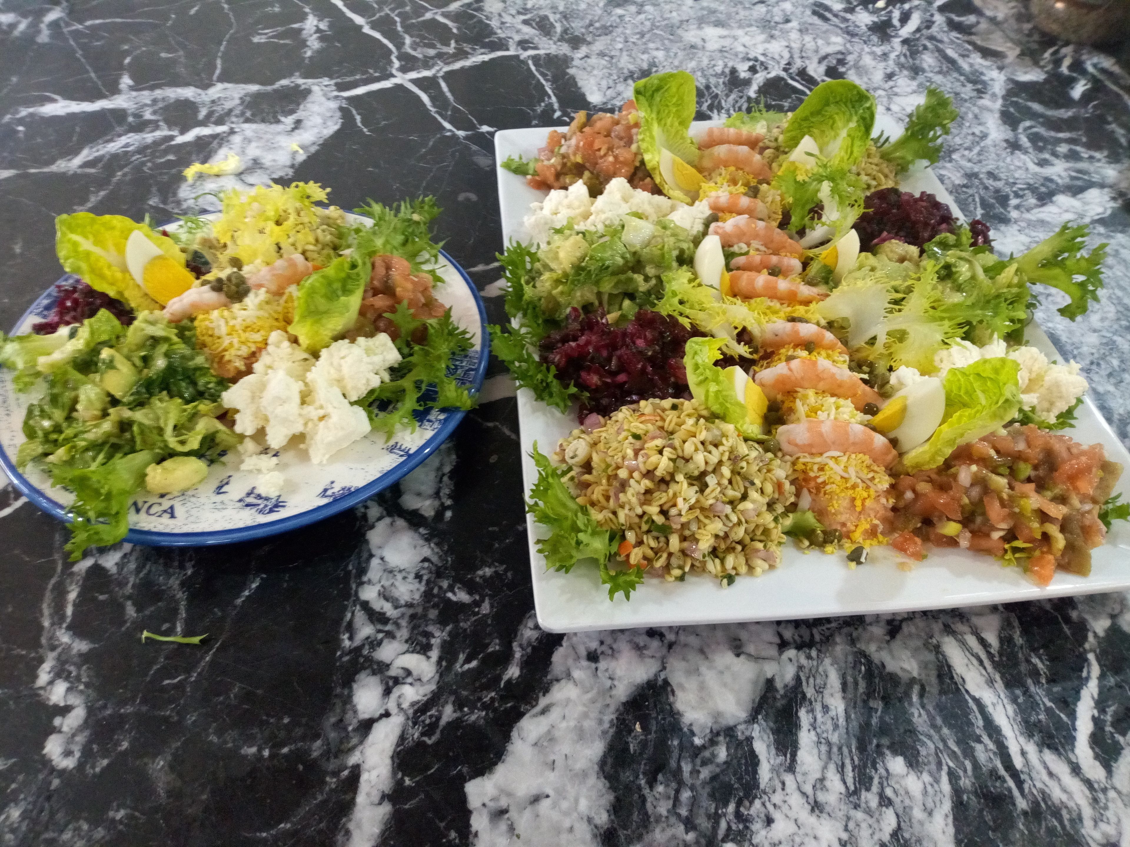 Dos platos de comida sobre una mesa de mármol.