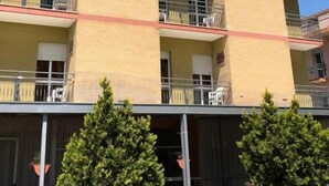 A multi-story hotel with a 'be' logo, balconies, and outdoor seating. - Be Hotel Rimini (Rimini)