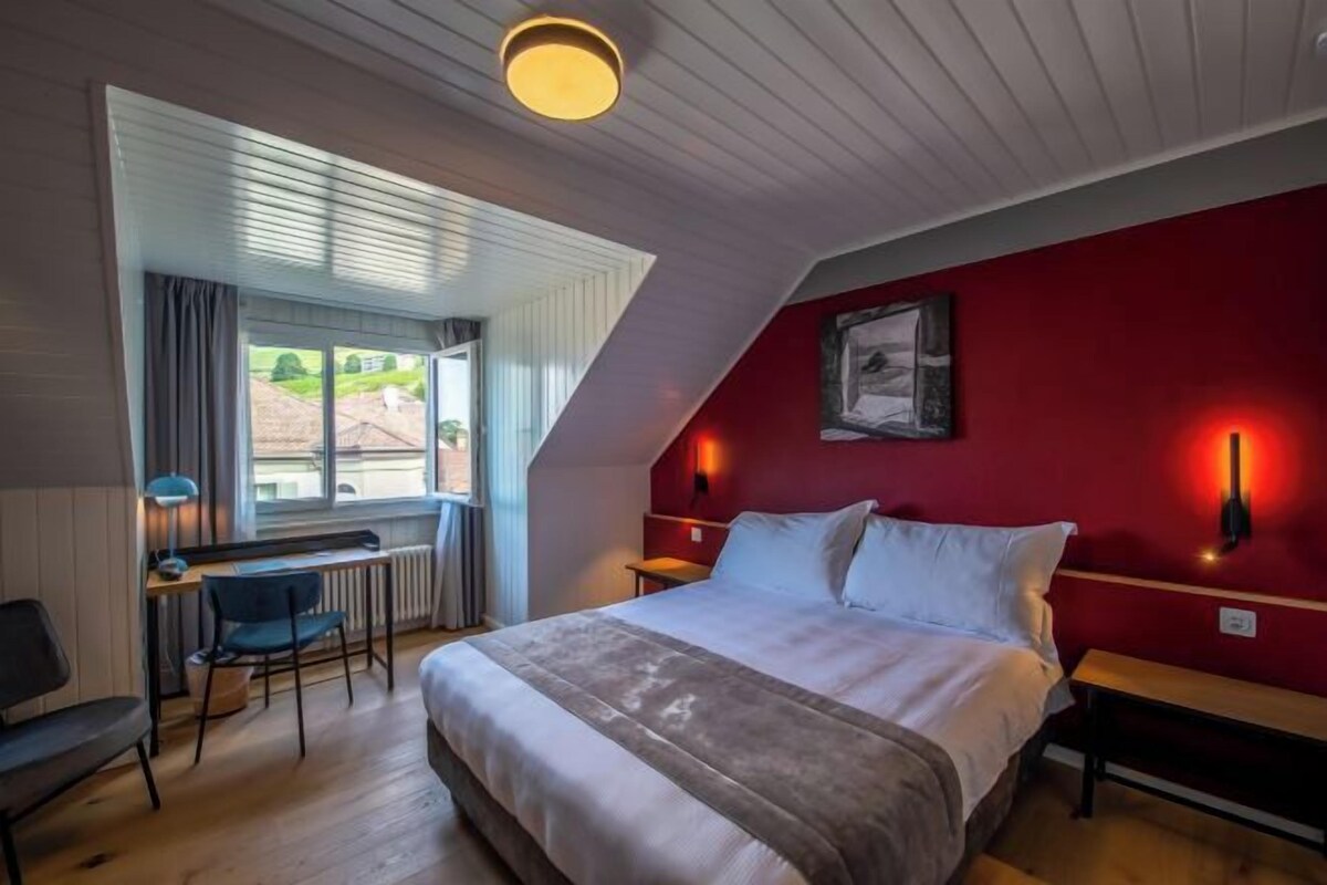 Un dormitorio con cama, escritorio y silla.