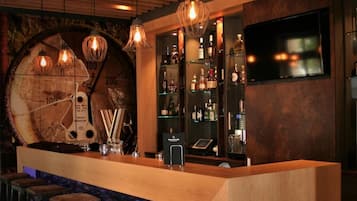 Eine Bar mit einer Holztheke, Hockstühlen und einer Wanduhr.