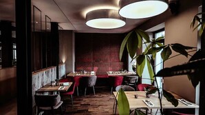 A restaurant interior with wooden flooring, red chairs, and tables. - Alexxanders Restaurant & Bordinghouse (Chemnitz)
