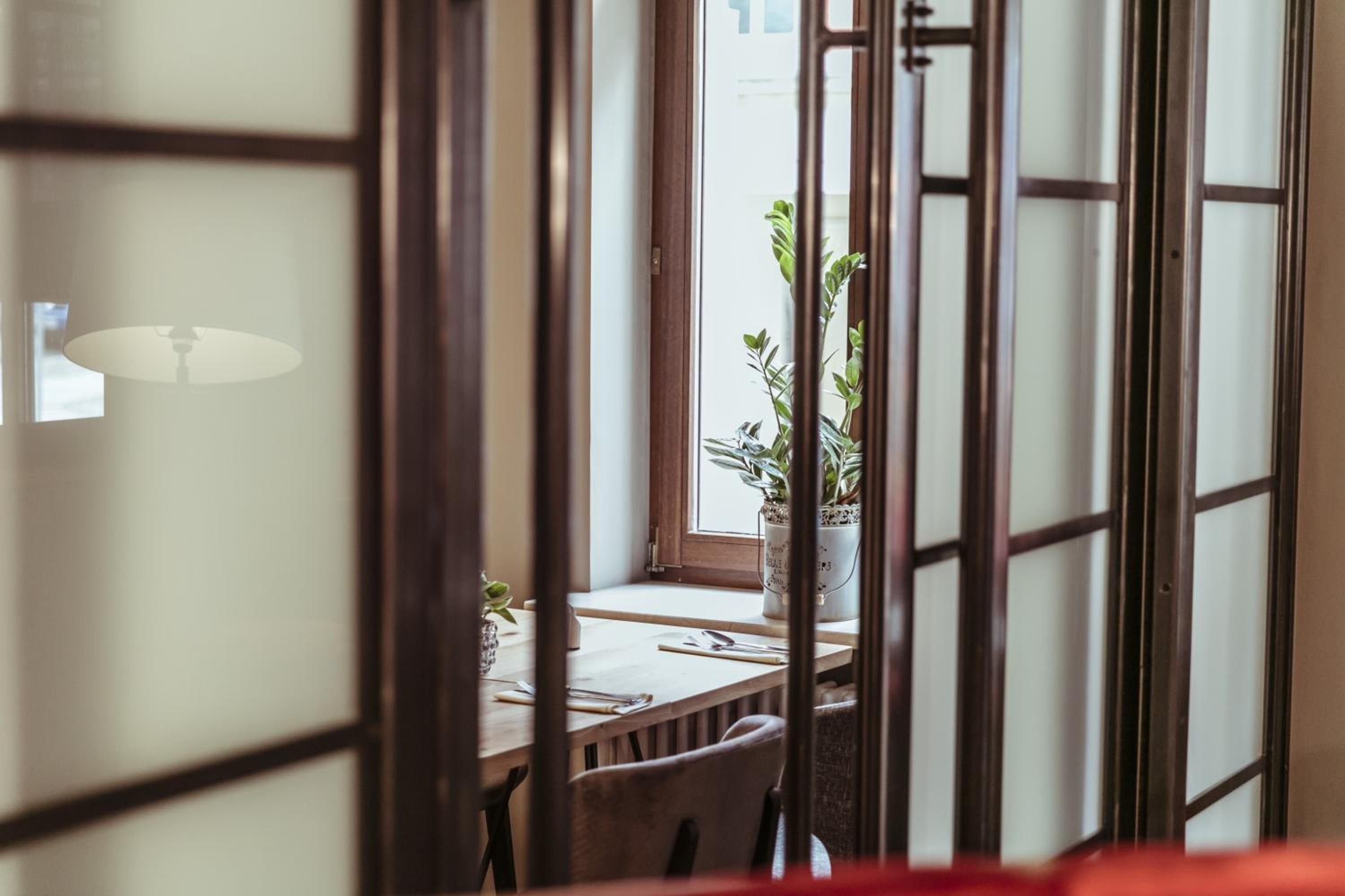 Ein traditioneller japanischer Raum mit Schiebetüren, einem Holztisch und einem Blumentopf.