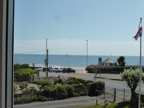 A coastal road with a view of the sea, a flag, and a building with a flagpole. - Bay Court (Bridlington)