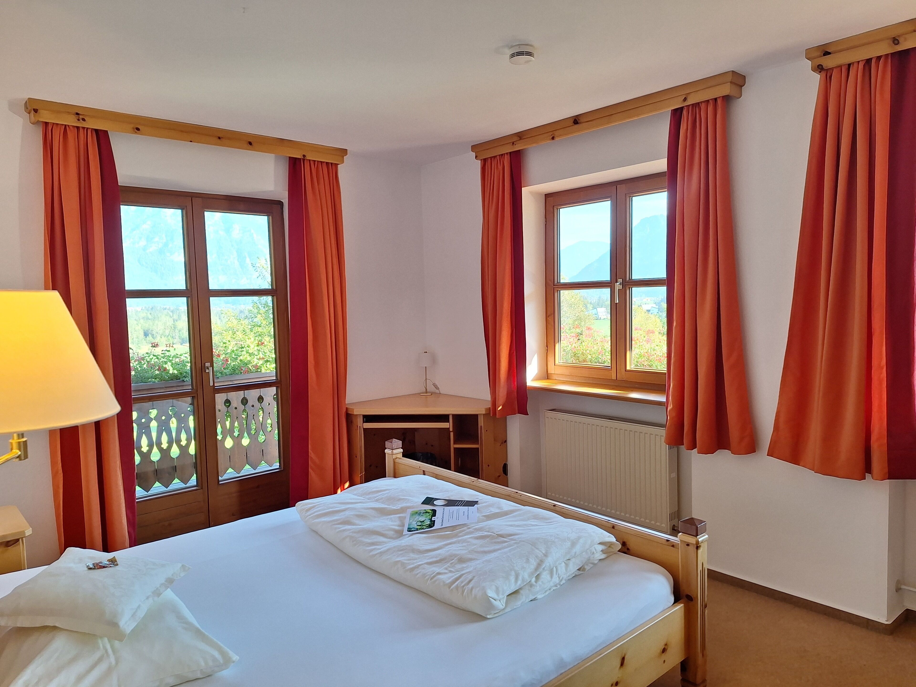 A bedroom with a bed, a window, and a radiator.