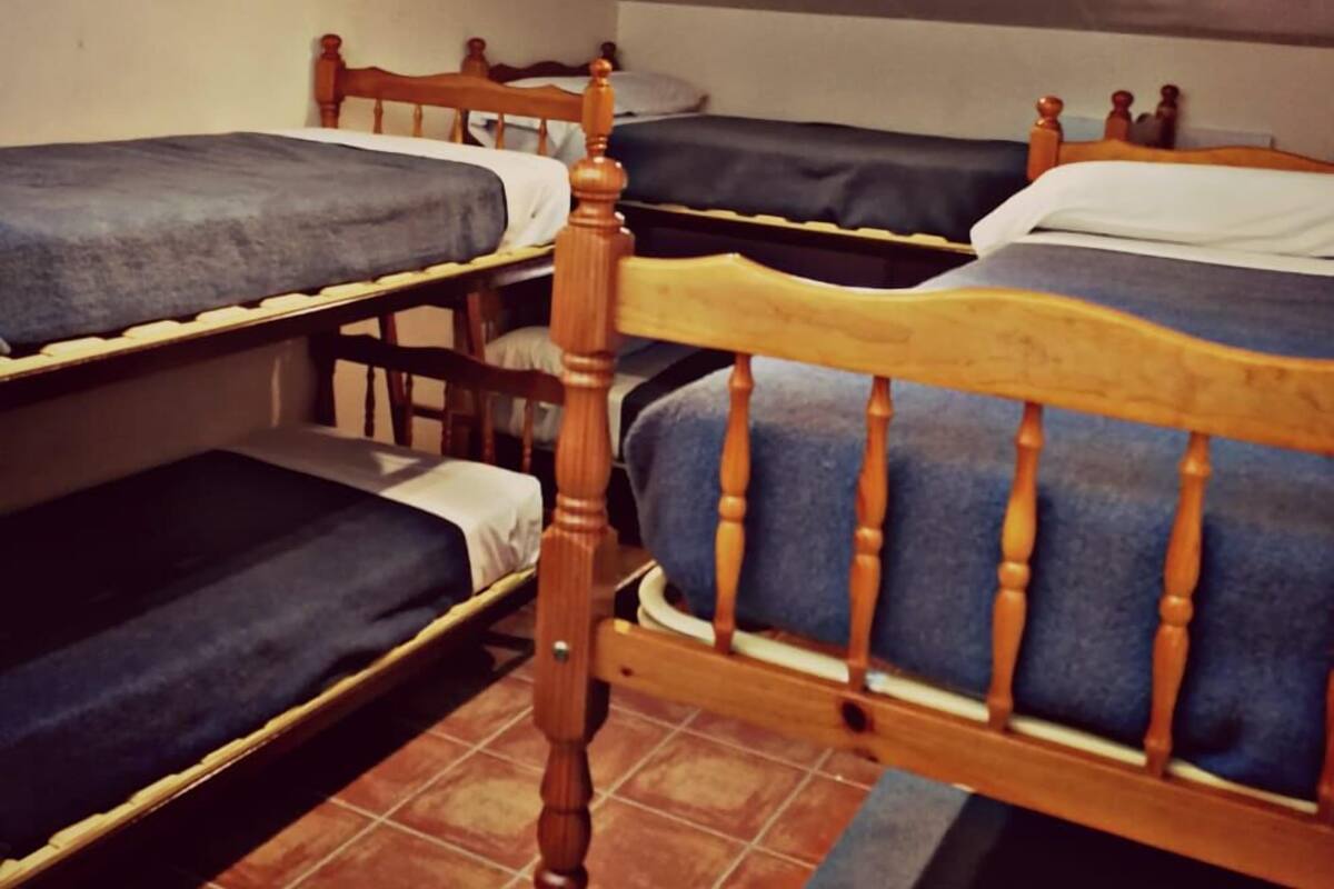 Ein Schlafsaalzimmer mit Etagenbetten und Fliesenboden.