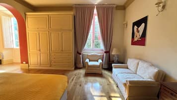 Ein Schlafzimmer mit einem großen Bett, einer Couch, einem Sessel und einem Kleiderschrank.