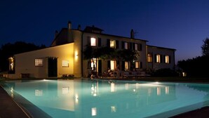 A large, modern hotel with a swimming pool, multiple balconies, and a well-lit exterior. - Agriturismo Villa Borgeri (Castagneto Carducci)