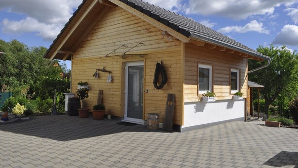 A wooden cabin with a pitched roof, a front door, and a small porch area. - Romantic quiet chalet with a beautiful garden (Algolsheim)