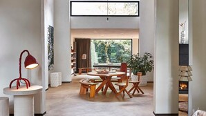 A modern living room with a dining area, a fireplace, and a large window. - Kind of OJ (Bruges)