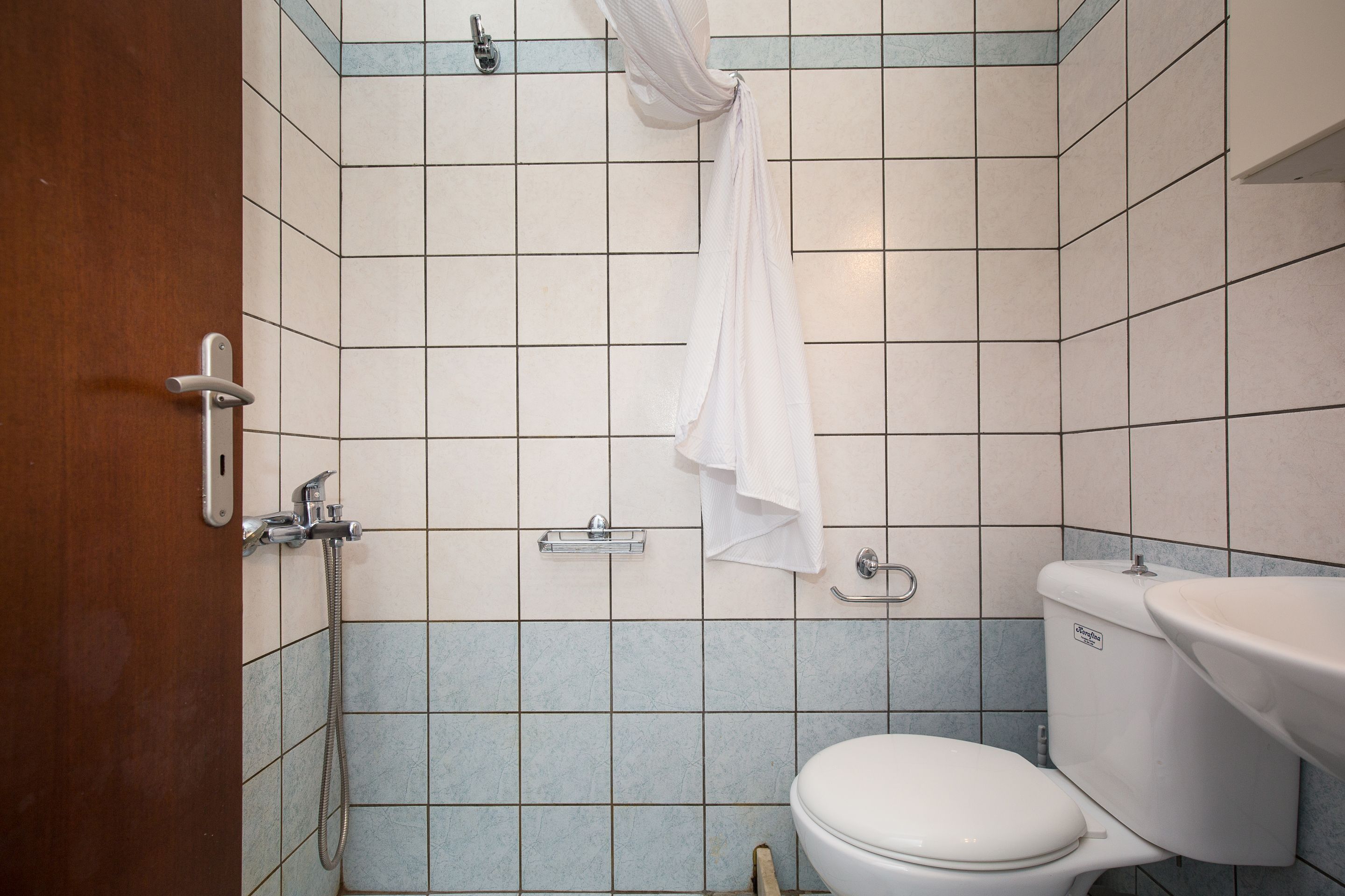 Une salle de bain avec des toilettes, un lavabo et une douche.